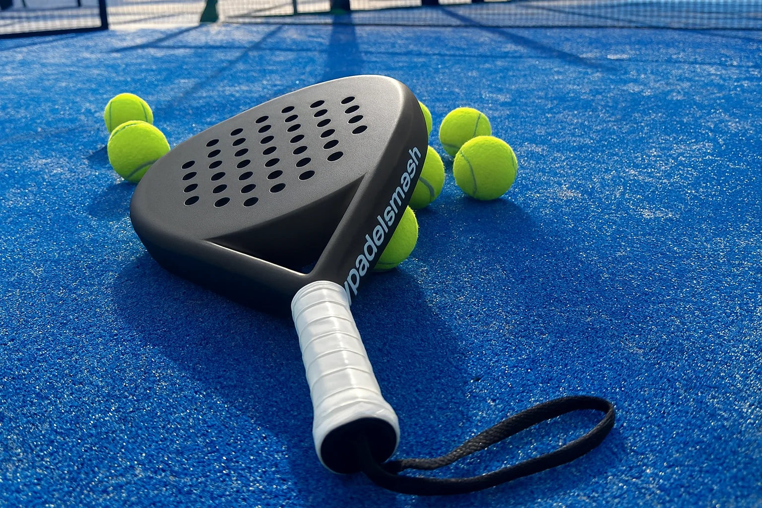 MyPadelSmash_Padelschlaeger_mit_Padelbaellen_auf_Padelplatz